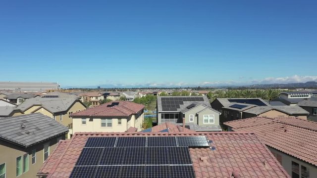 Photovoltaic Solar Panels on Rooftop of Residential Houses in Tustin, Los Angeles, California. Ascending Aerial