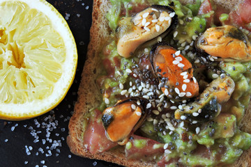 Fototapeta na wymiar Guacamole toasts with mussels. Healthy snack. Keto diet.