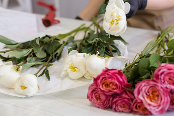 white peonies and red roses in a flower shop