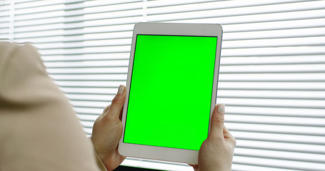 Close up of female hands holding white tablet in the office