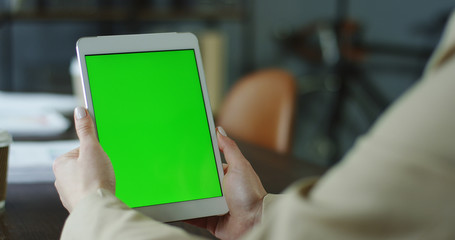 Mockup image of woman's hands holding and using tablet with blank white screen