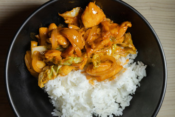 A plat of rice with korean chilli chicken.