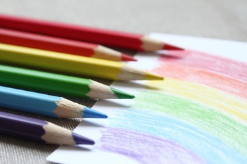 Colored pencils with crayon child's drawing of a rainbow that during Covid-19 coronavirus pandemic became symbol of hope, while traditionally it used to be the one of LGBT community and gay pride.