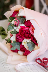 beautiful bouquet of red and white peonies and roses in a flower shop