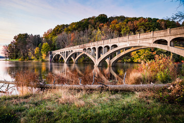 Wide shot of an abandoned bridge over Lake Ontelaunee in autumn