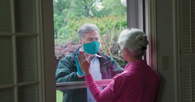 A mature man following the social distancing mandate issued due to COVID19 by not entering the home of a high risk elderly relative he wants to check on.