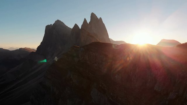Aerial Drone Footage View on Majestic panorama of beautiful sunset or sunrise in the Italian picturesque resort Seceda dolomite mountains. Beautiful landscape near the edge of world at 4K resolution.