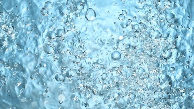 Water splashing on blue background, super slow motion. Filmed on high speed cinema camera, 1000 fps.