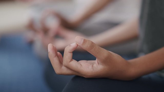 Group of Hand doing yoga exercises with lotus while sitting on yoga mats in a gym, Close-up of hand young woman.Concept of relaxation and meditation
