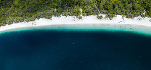 People taking a swim at stunning blue Lake Mackenzie Fraser Island Australia with crystal clear water