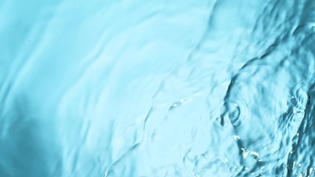 Water splashing on blue background, super slow motion. Filmed on high speed cinema camera, 1000 fps.