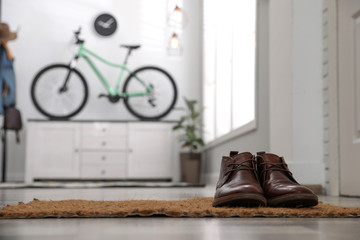 Fototapeta na wymiar Hallway interior with stylish furniture and bicycle, focus on shoes