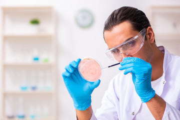 Young male nutrition expert testing food products in lab