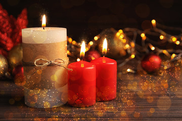 Burning candles and Christmas decoration on wooden table, bokeh effect