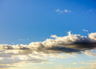 Beautiful puffy clouds at sunset isolated against pastel blue skies