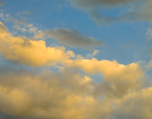 Beautiful puffy clouds at sunset isolated against pastel blue skies