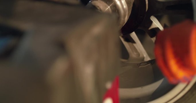 Mechanic releases air from the tire through the nipple on a machine tool