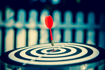 Bullseye(bull's-eye) or dart board has dart arrow hitting the center of a shooting target for...