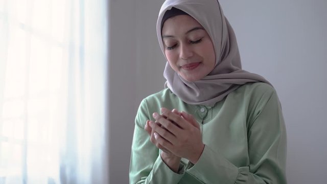 Asian hijab young women pray after studying the Koran in the room