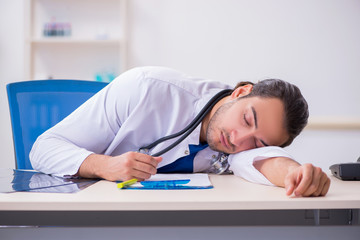 Naklejka premium Young male doctor being tired after night shift