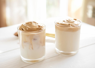 Iced frothy Dalgona Coffee, a trendy fluffy creamy whipped coffee. Korean drink latte espresso with coffee foam. made of instant coffee, sugar, hot water and milk. morning time.