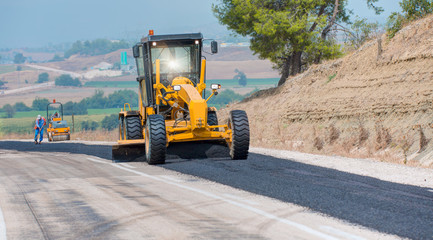 Workers repairs road under the program of planned