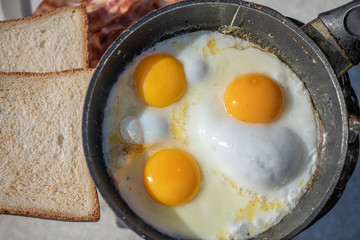 Tourist tomorrow in nature. Fried eggs on hot gas