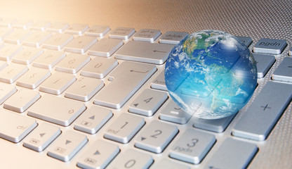 Glass globe on blured laptop keyboard "Elements of this image furnished by NASA "
