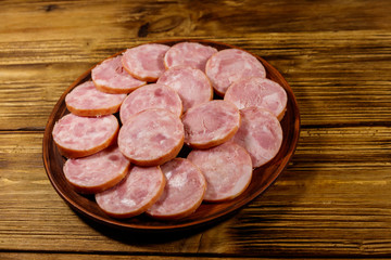 Ham sausage on a plate on wooden table