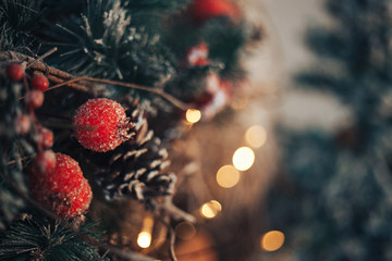 Christmas tree branch with toys balls and lights close-up blurred bokeh background