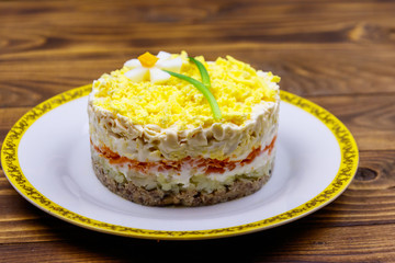 Obraz na płótnie Canvas Traditional russian layered salad Mimosa with spring decoration Daffodil. Decoration is made of egg, green onion and carrot
