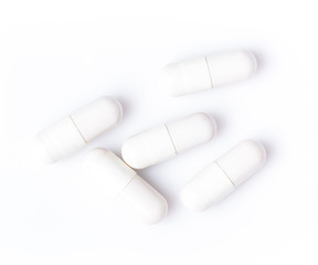 White capsules on a white background