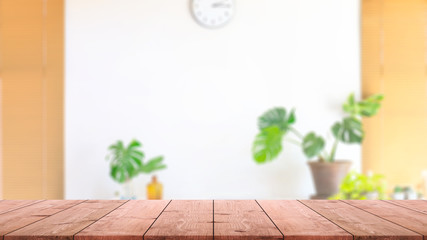 Empty wood table top and blurred home interior with green leaf in living room background. - can used for display or montage your products.