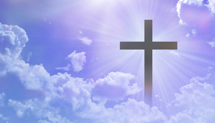 The Christian cross appears bright in the pastel sky, with a soft, fluffy white cloud, with light that shines as a beautiful background and leads to peace and paradise.