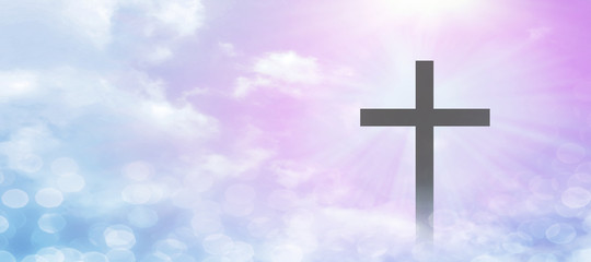 The Christian cross appears bright in the pastel sky, with a soft, fluffy white cloud, with light...
