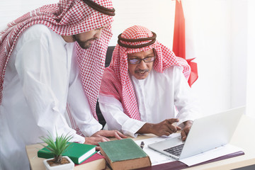 Two Arab business man working on laptop computer, discussing project in laptop at meeting