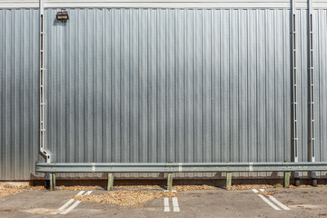 Shiny metal wall on a building with parking spaces in front - Powered by Adobe