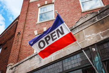 Obraz premium Red white and blue flag Open sign on a business