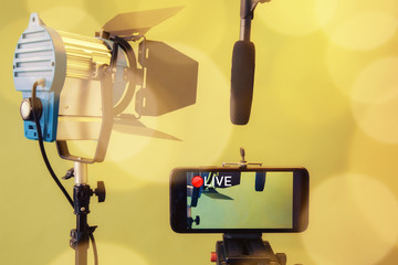 Live Stream Video Multimedia Concept.smartphone , microphone and reflectors on the Yellow background