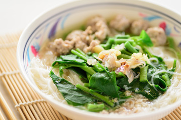 Rice noodles soup with pork meatball and vegetables in a bowl, homemade Asian food