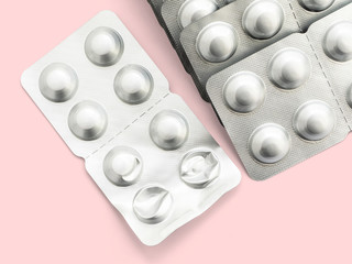 A large number of capsules in a silver package on a pink background, isolate, close-up. A large number of medications for the treatment of various diseases. Tablet for all diseases and viruses
