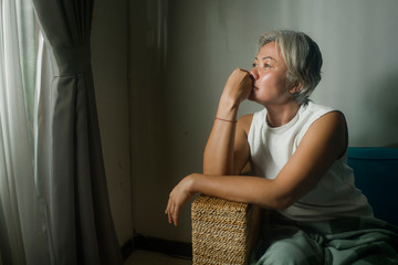 mature lady crisis -  middle aged woman with grey hair sad and depressed on couch feeling frustrated and lonely thinking about aging lonely suffering depression