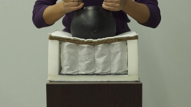 Woman puts heavy weight on orthopedic mattress with a coconut coir slow motion