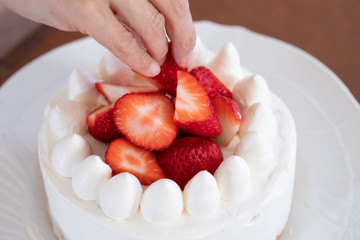 スポンジケーキに苺を飾る様子