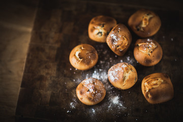 Freshly baked muffins with raisins and dried apricots, shot on a dark background. Background for baking and cooking.