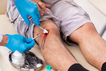 Leg injured man visiting old doctor in first aid concept