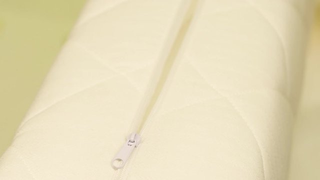 White female hand unfastens an orthopedic pillow cover made friendly materials