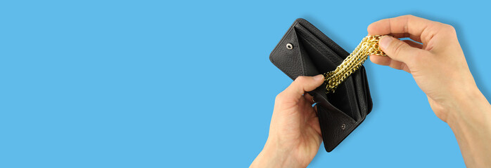 hands takes out gold yellow jewelry chain of black leather wallet, investment in treasure, banner...