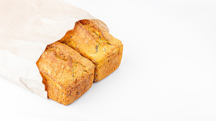Two loaves of whole-grain bread in eco bag on white background. Freshly baked homemade square bread. Organic and vegetarian food concept. Copy space for text