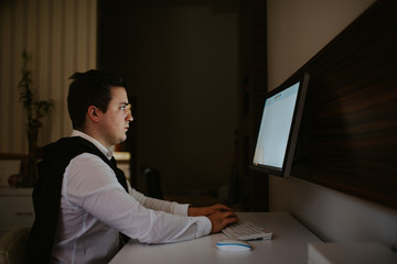 
Young caucasian businessman in the office working on computer. Businessman, work and technology